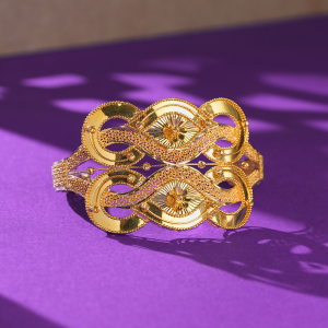 22KT gold bracelet with two almond-shaped flower centres, polished loops and dotted mesh bands.