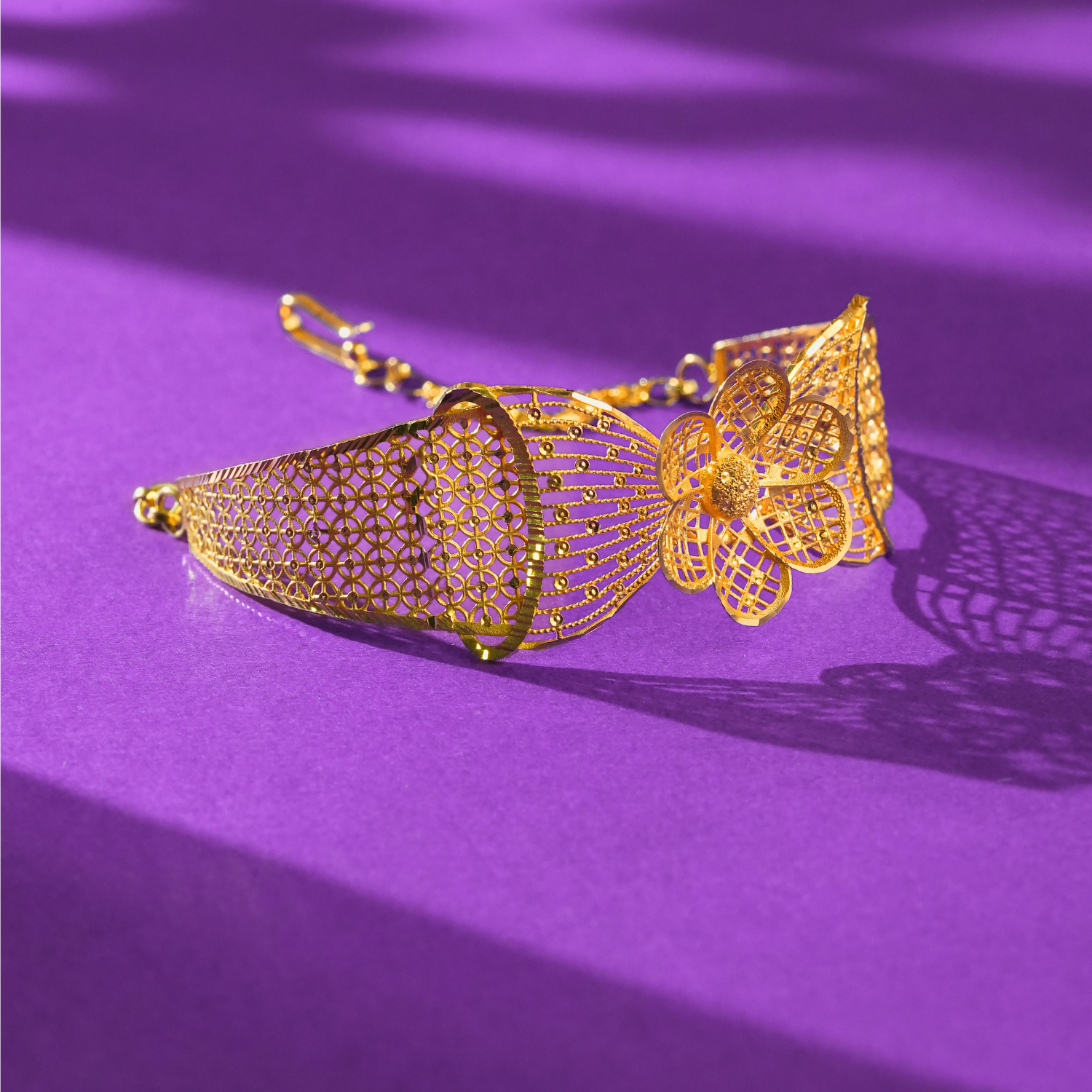 22KT gold bracelet with a large mesh-petal flower, fan of beaded lines, linked-circle band and link chain.