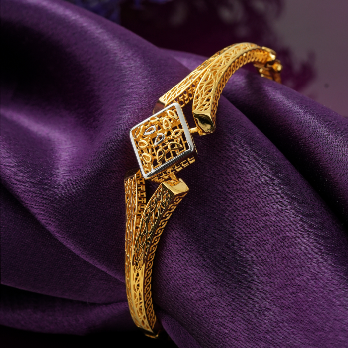 18KT gold bracelet with a tilted rhodium-framed square centre, leaf cut-outs and overlapping leaf-vein bands.