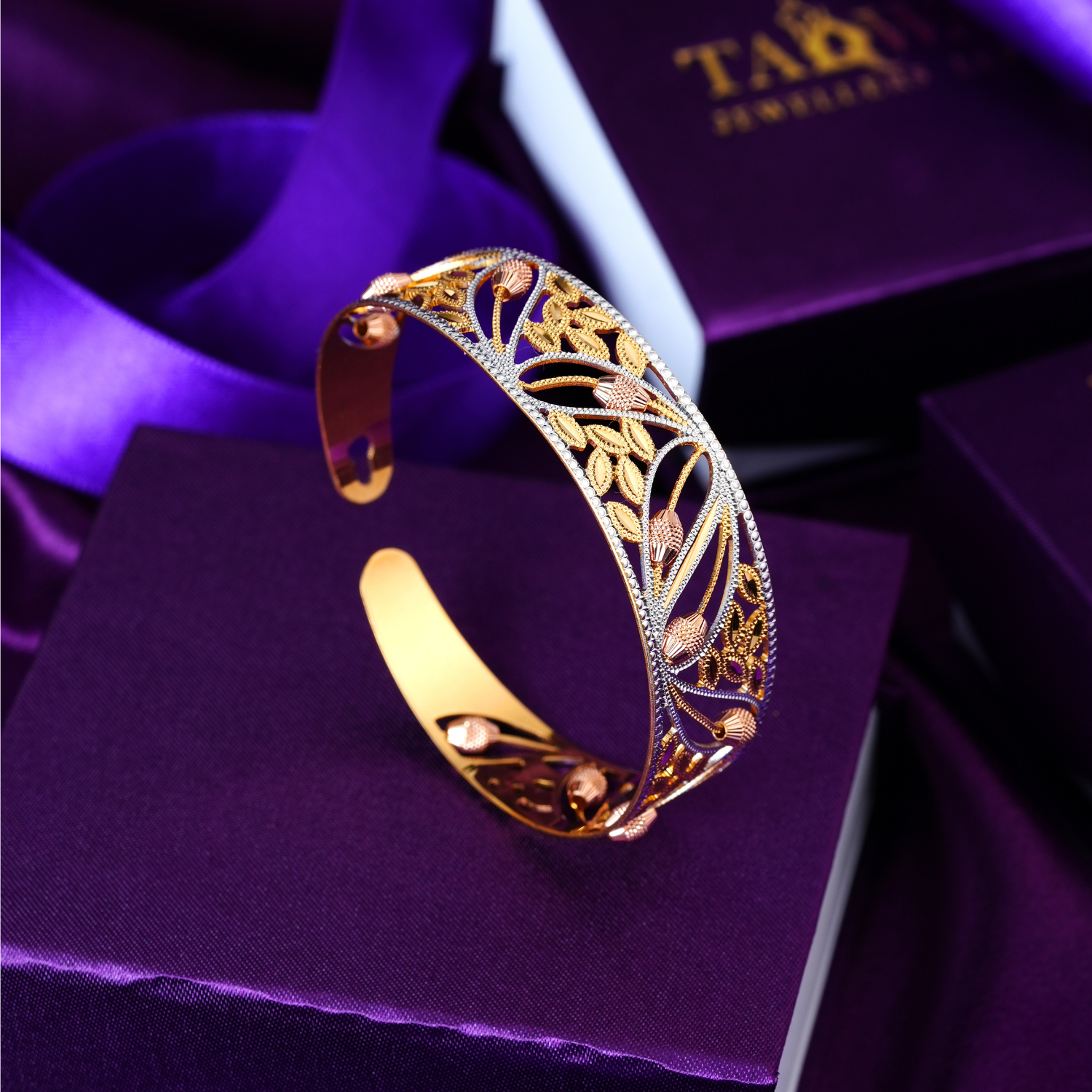 22KT open cuff gold bracelet with leaf and bud cut-outs in yellow gold, rose gold and rhodium.