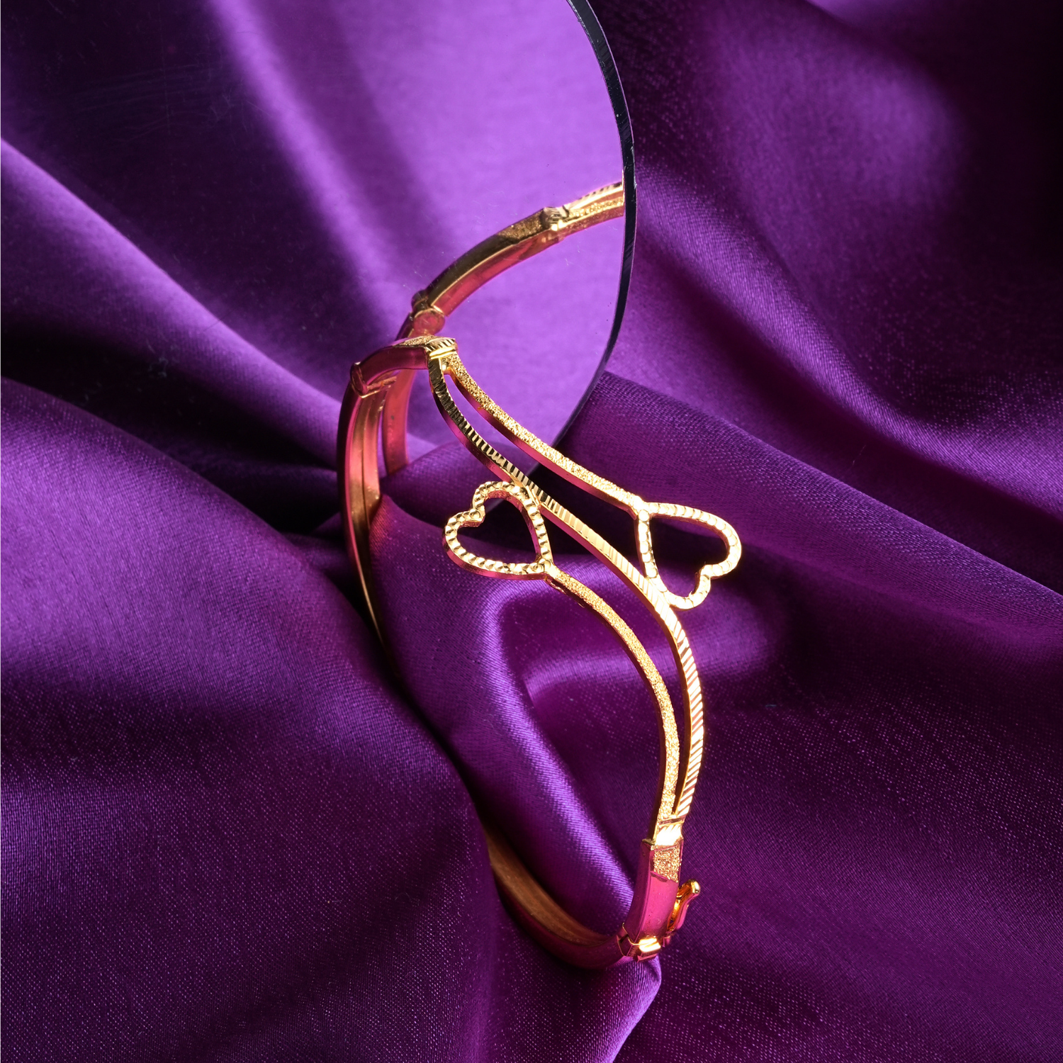 Heartstrings 18kt gold bracelet by Taqwa Jewellers with an open, intertwined heart design and dual-finish polished and textured band.