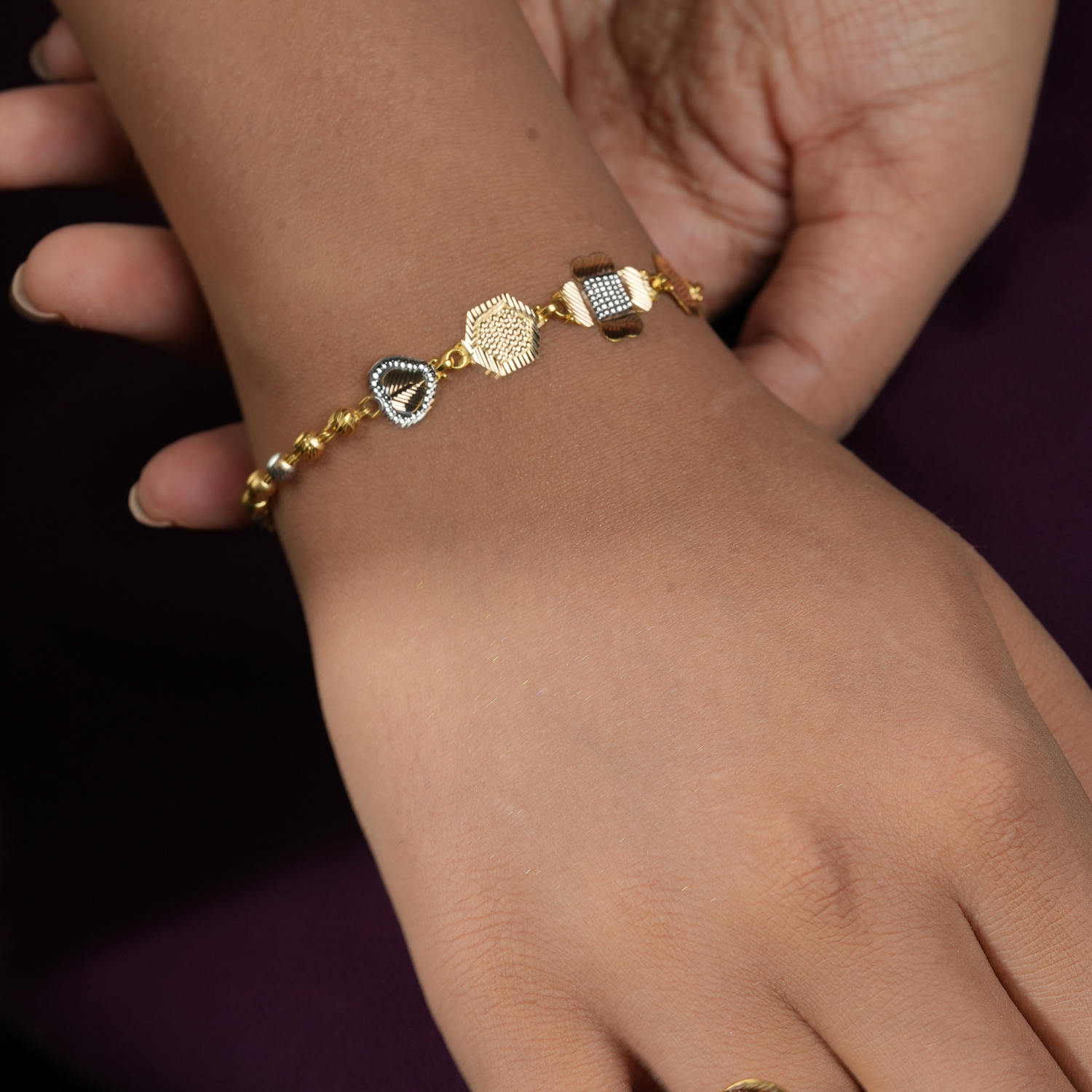 Trio Charm 18kt gold bracelet by Taqwa Jewellers with tri-tone yellow gold, rose gold and rhodium motifs.