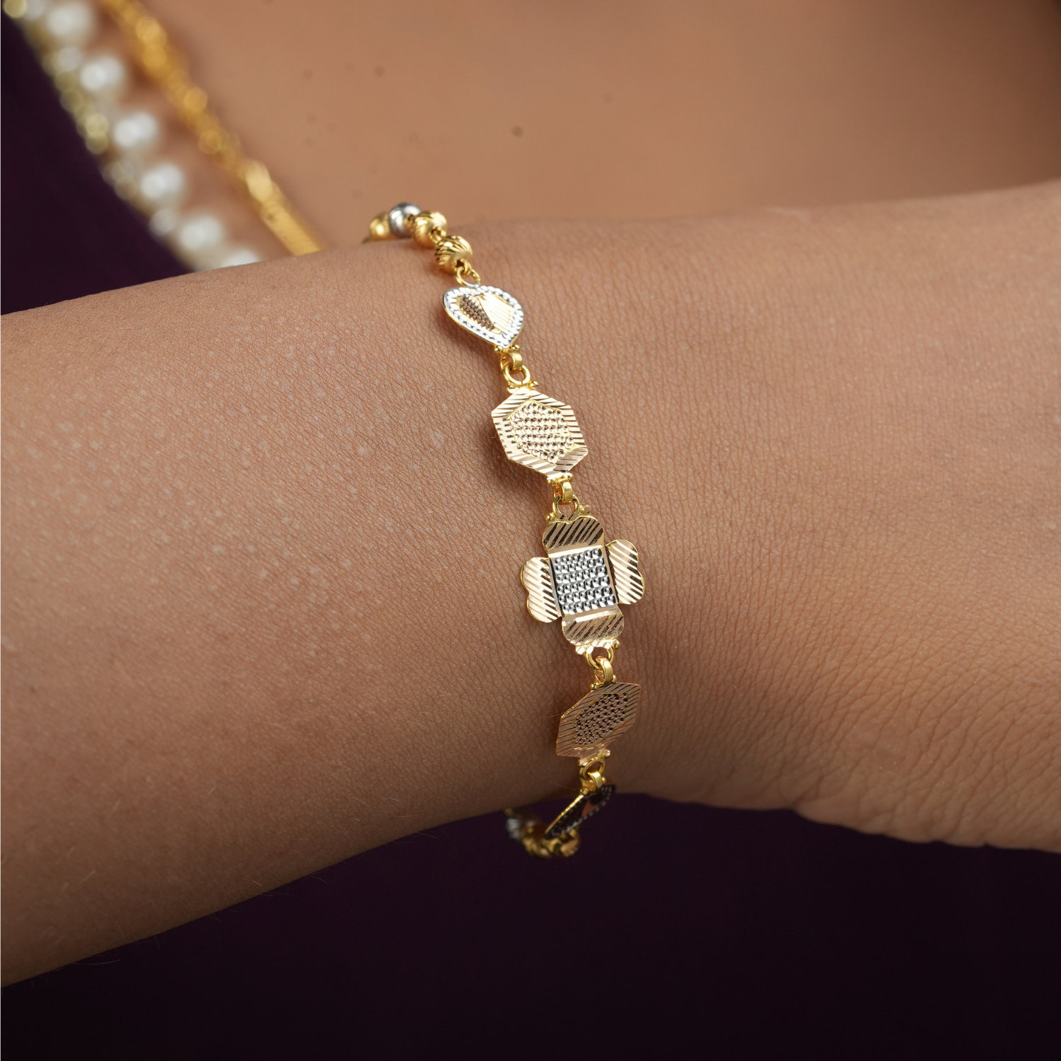 Trio Charm 18kt gold bracelet by Taqwa Jewellers with tri-tone yellow gold, rose gold and rhodium motifs