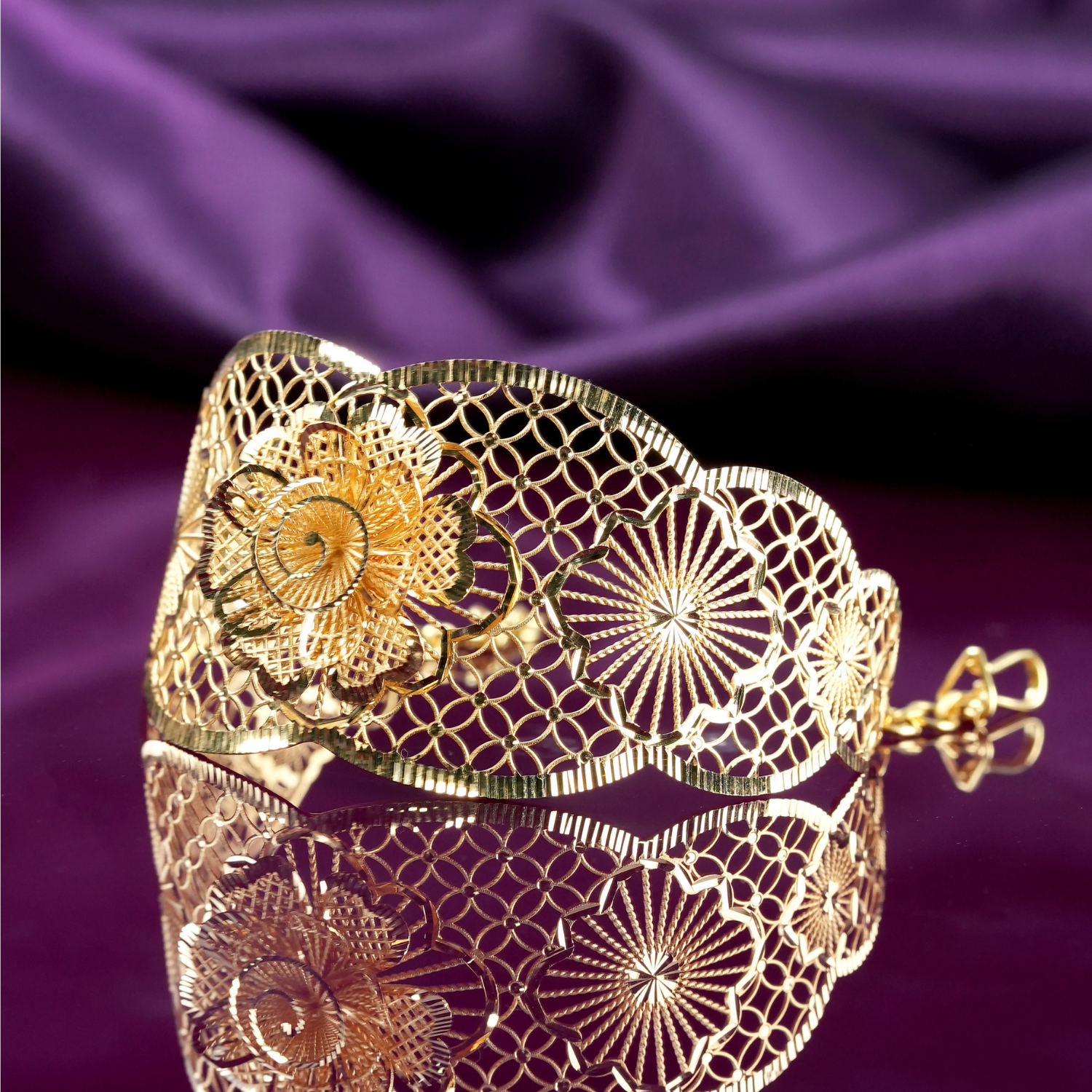 Scallowray 18kt gold bracelet by Taqwa Jewellers with a layered flower centre, sunburst medallion and linked-circle lattice detailing.
