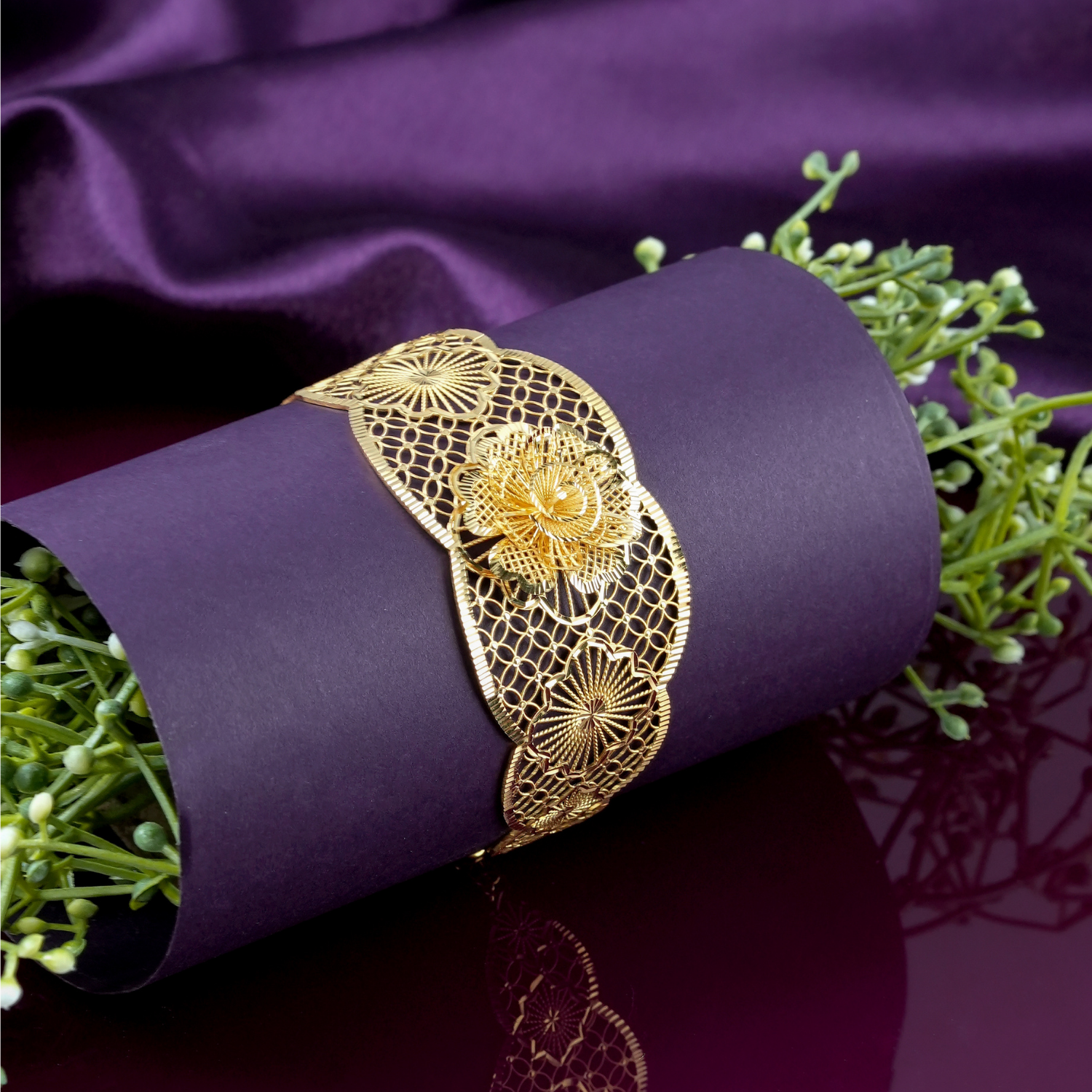 Scallowray 18kt gold bracelet by Taqwa Jewellers with a layered flower centre, sunburst medallion and linked-circle lattice detailing.