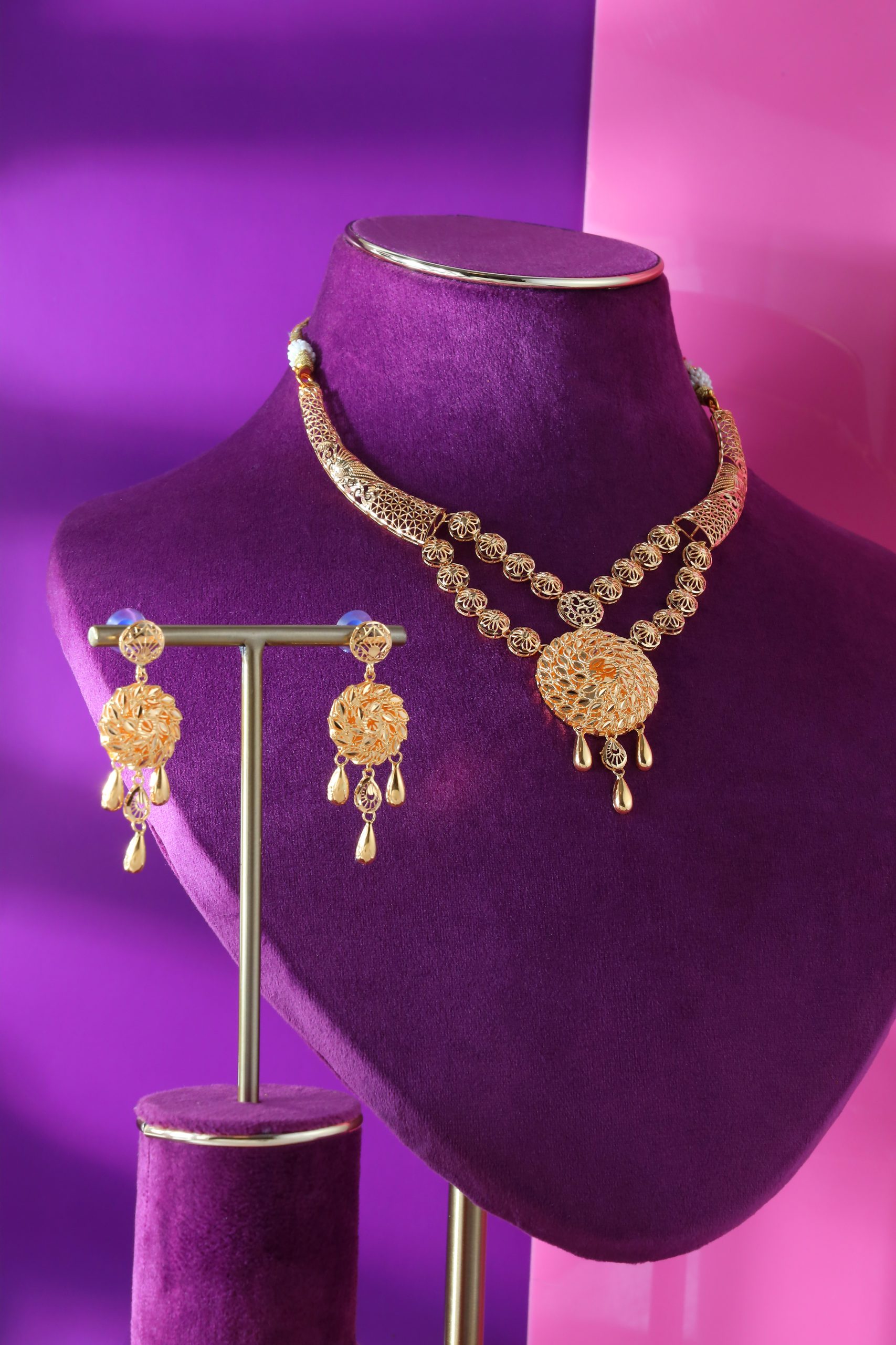 Set of gold necklaces Gunes Altin containing circle sun motifs, teardrop pendants and a pair of ear tops.