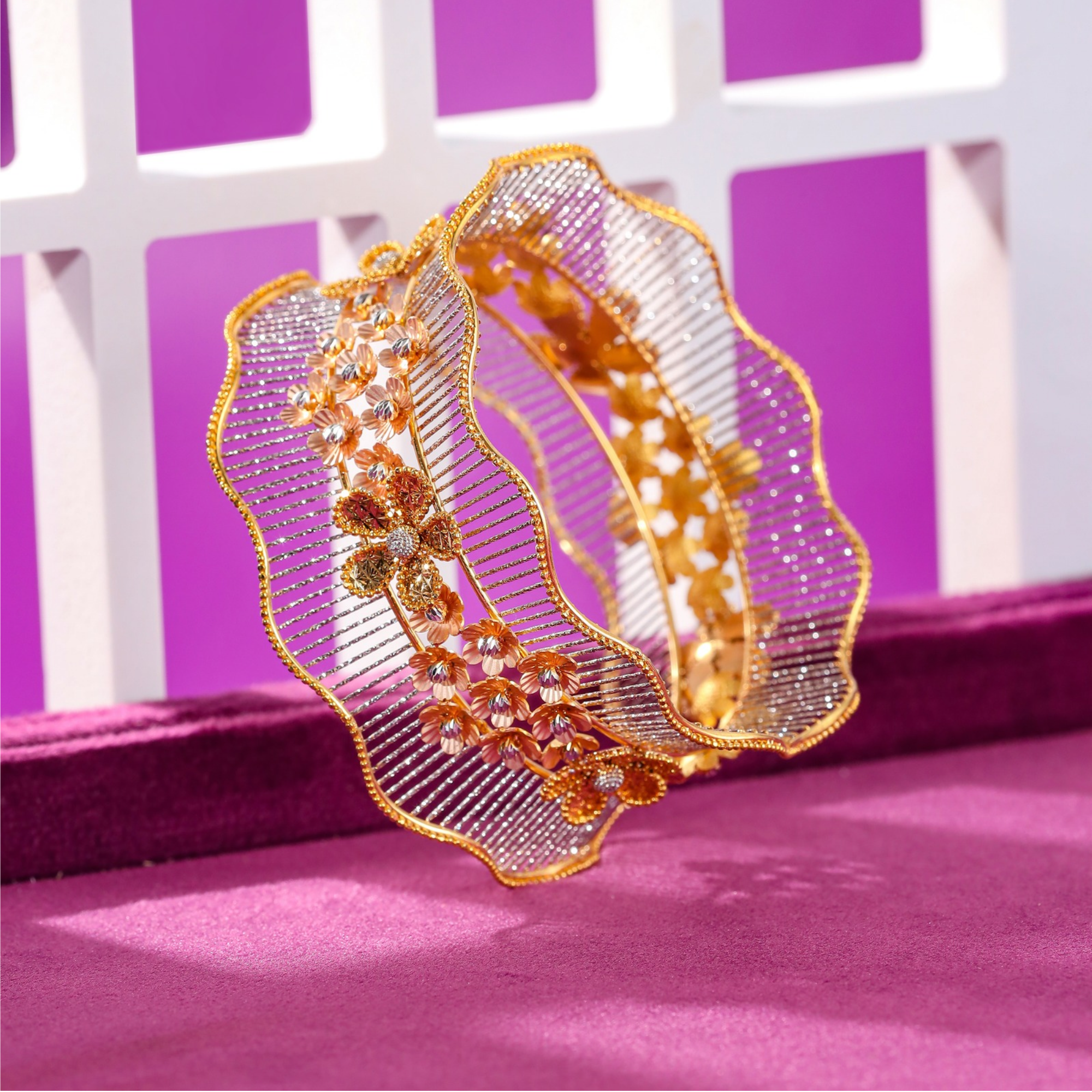 22KT gold bracelet with a wide wavy band of fine rhodium lines and a column of small flowers