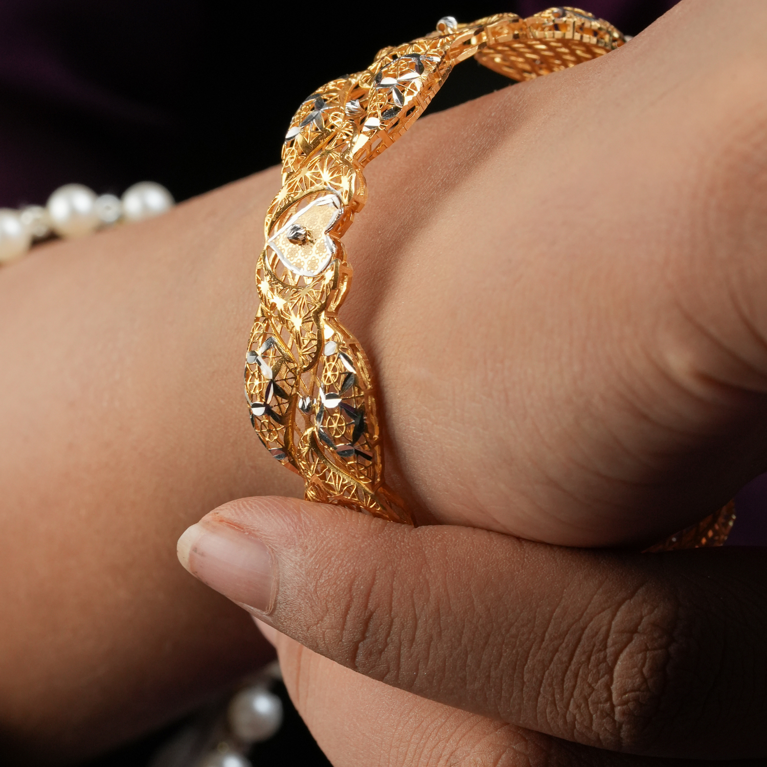 Qulub 22KT Gold Bangles with heart motifs, open lattice work, and rhodium detailing.