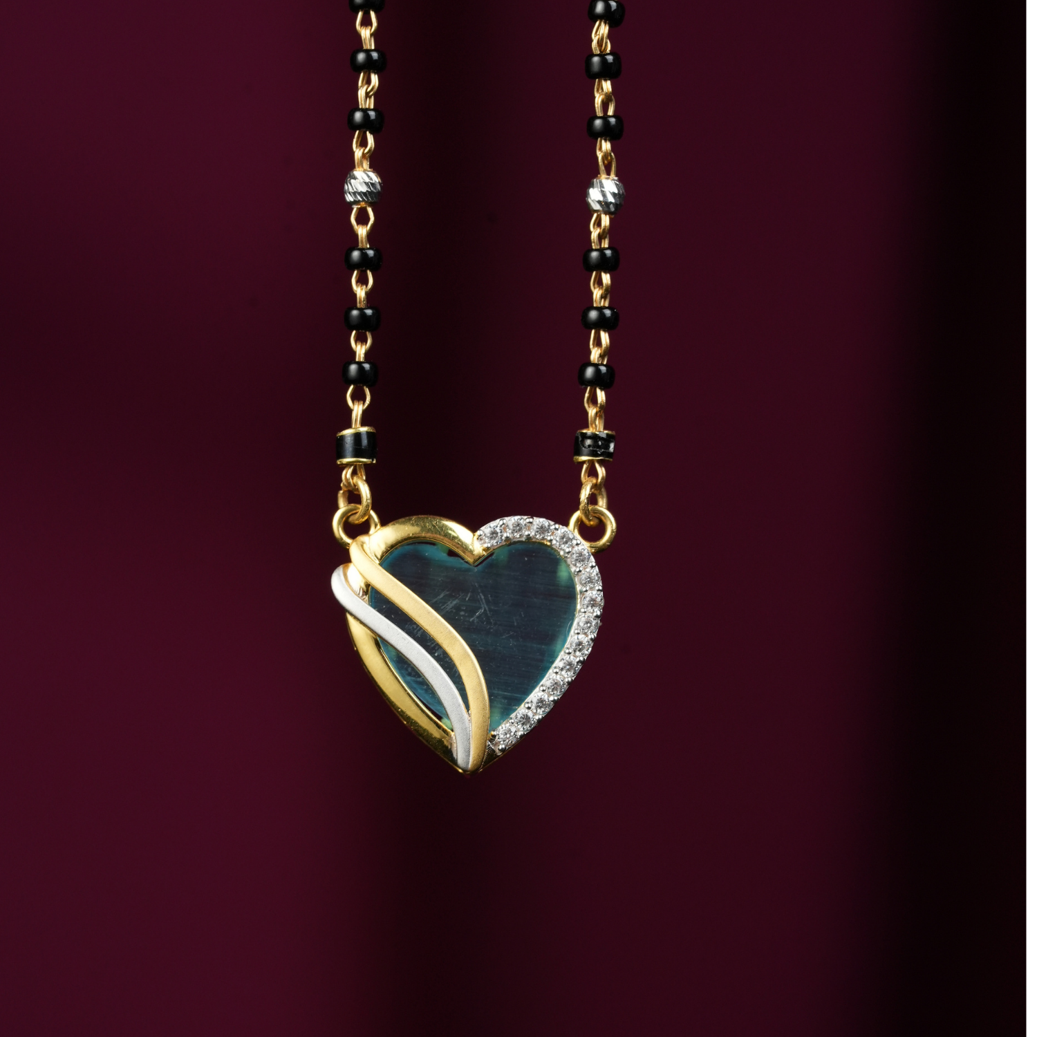 Love Knot Gold Mangalsutra in 18K gold with heart-shaped diamond pendant and black-bead chain.
