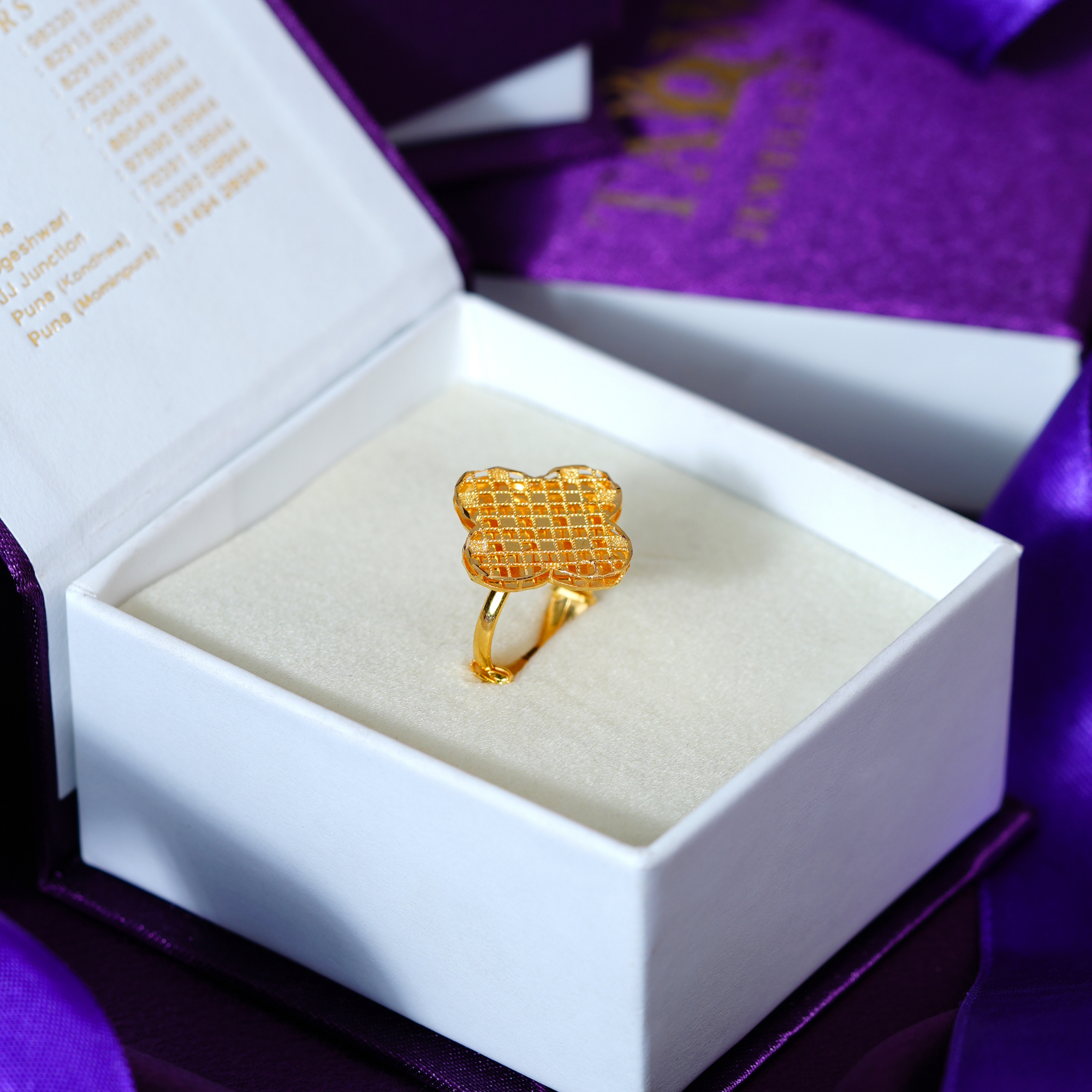 Fancy 22kt gold ring with a four-lobed clover top covered in a fine diamond grid of beaded gold lines