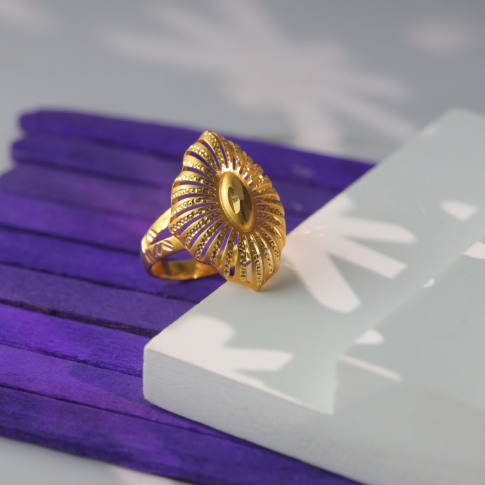 Hollow 18kt gold ring with a pointed oval top of dotted ribs fanning from a polished marquise center.