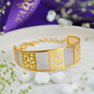 Cloverleaf 18kt dual-tone gold bracelet by Taqwa Jewellers with alternating laser-cut floral and striped panels.