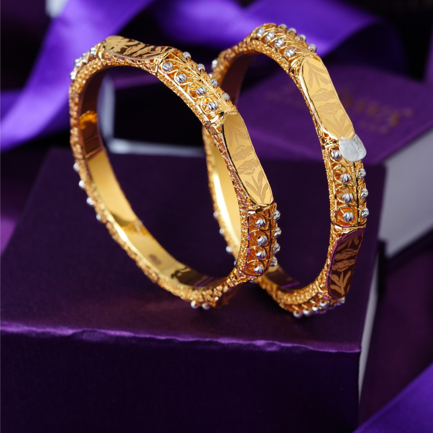 Zayra 22KT gold bangles with engraved panels, stone accents and fine gold bead detailing.