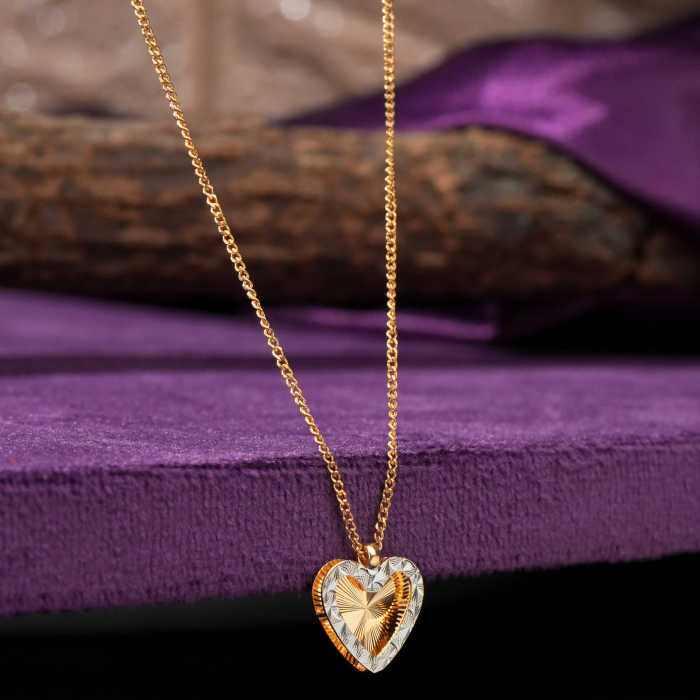 Ember 18KT gold chain with a heart pendant, cut rays and a rhodium border by Taqwa Jewellers.
