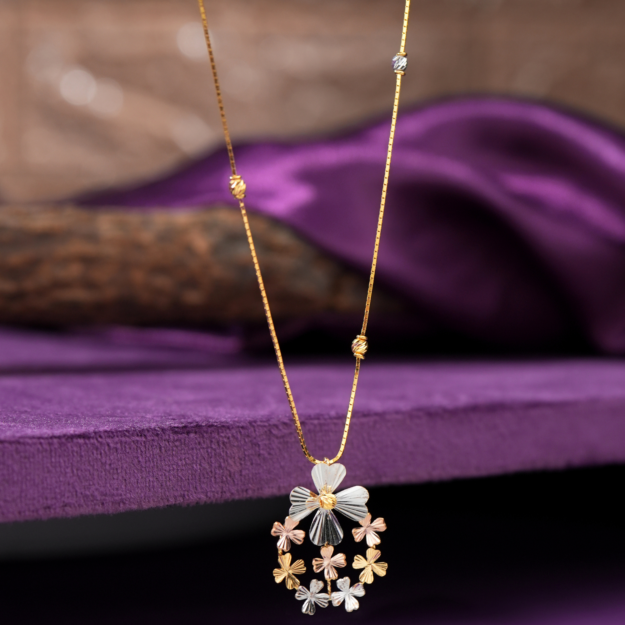Meadow 18KT gold chain with a tricolour floral cluster pendant and rhodium and gold beads, by Taqwa Jewellers.