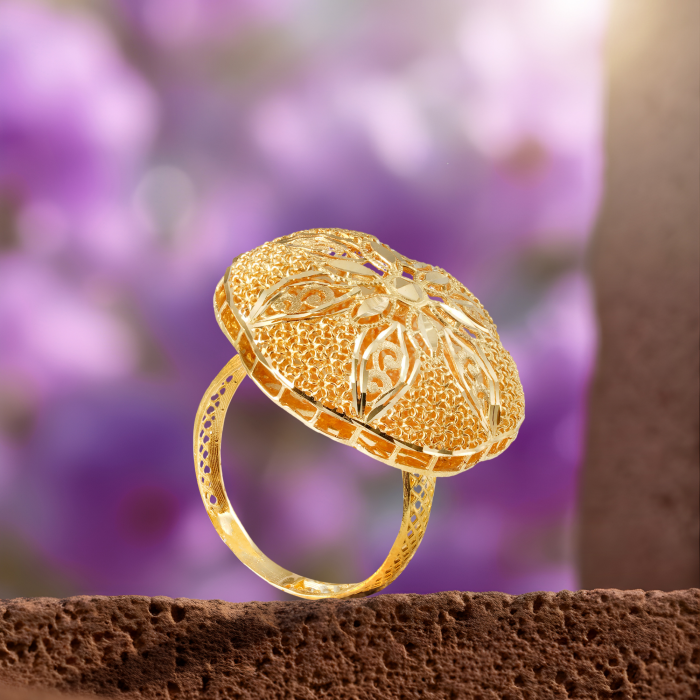 Arabic 18kt gold ring with a raised oval dome, a diamond-cut star of petals with scrolls and a lattice band.