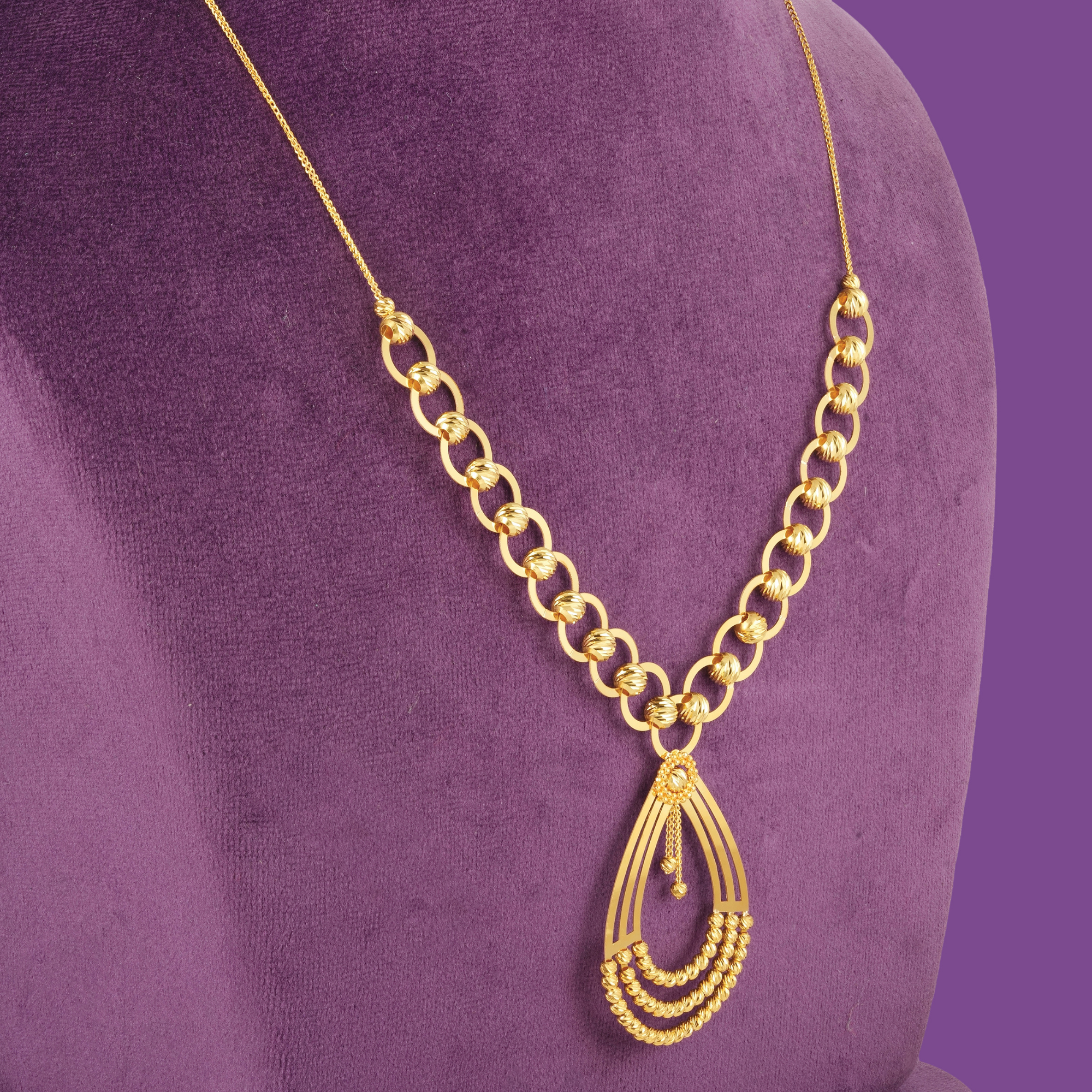 18KT gold necklace set with bracelet, ring and earrings in open rings, teardrop frames and cut gold beads.