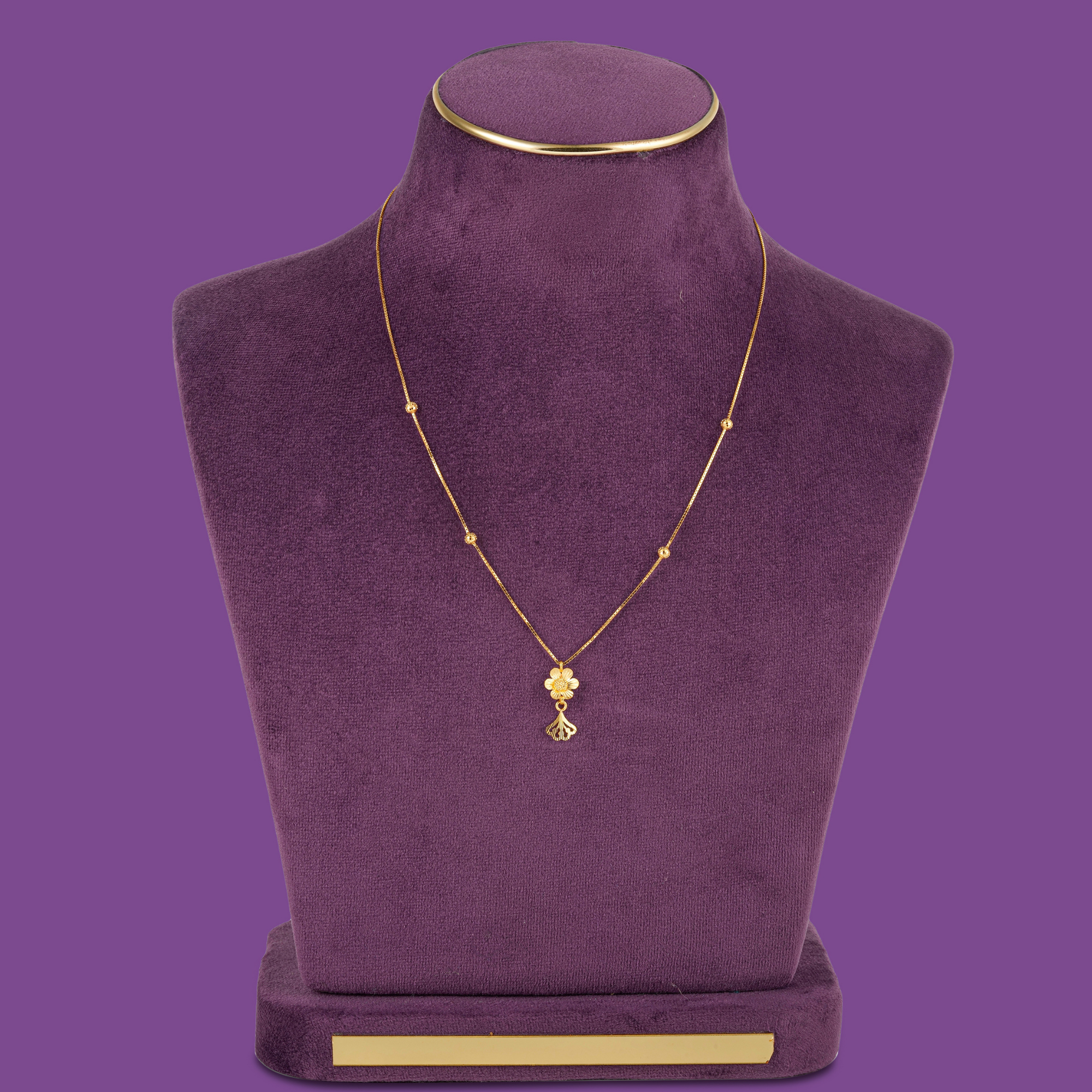 A 22KT gold box chain with a five-petal flower pendant and fan-shaped drop, by Taqwa Jewellers.