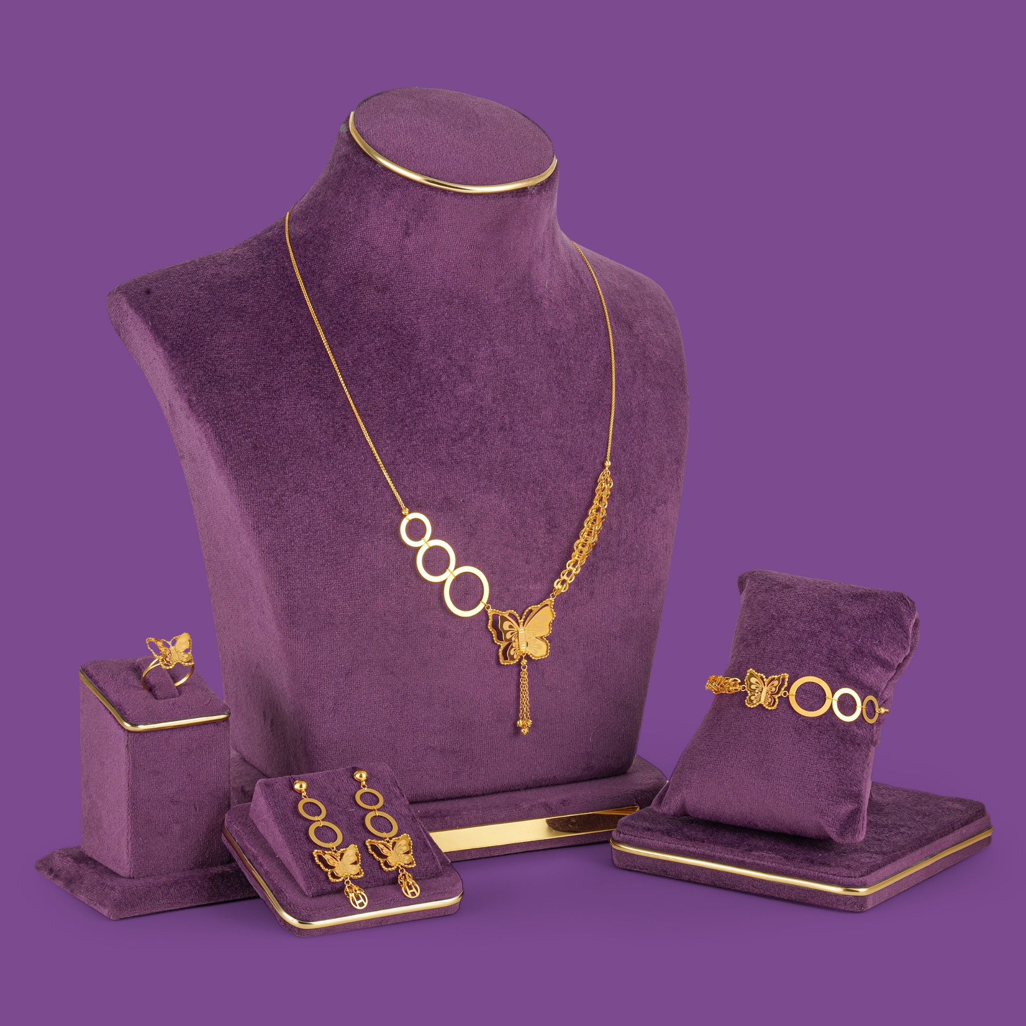 Winglet 18KT gold necklace set featuring a butterfly motif, linked oval elements, matching earrings, bracelet and ring by Taqwa Jewellers.