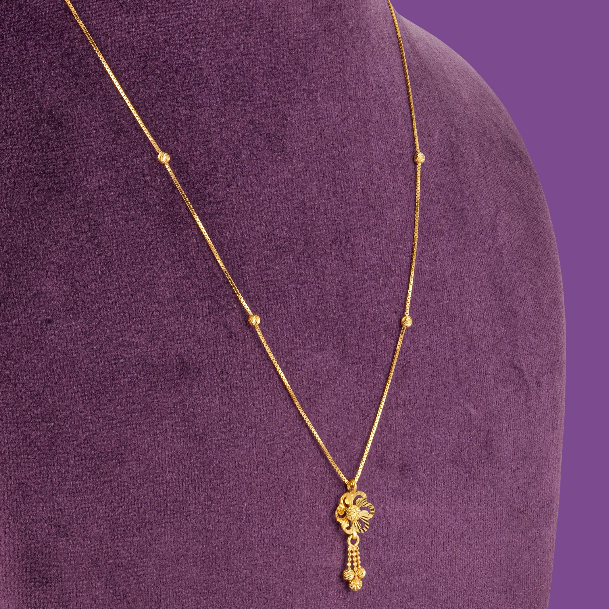 Wisp 22KT gold chain with four small beads, a flower pendant and a beaded tassel, by Taqwa Jewellers.
